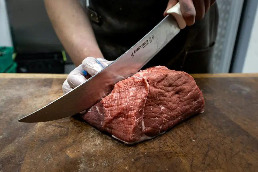 Butcher cutting meat with a knife